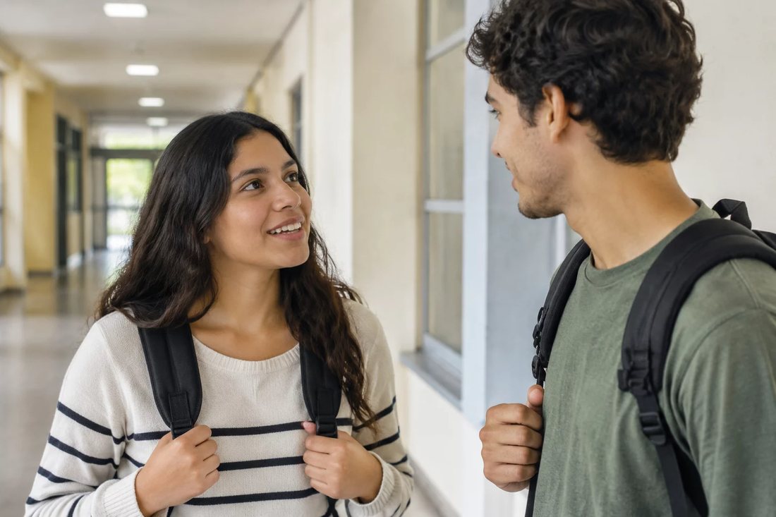 Dois estudantes de mochila continuam a discussão no corredor depois da sessão
